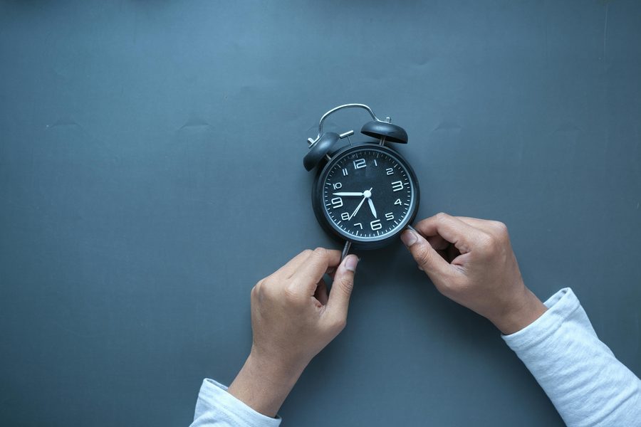 Mãos ajustando relógio, simbolizando consulta psiquiátrica sem pressa