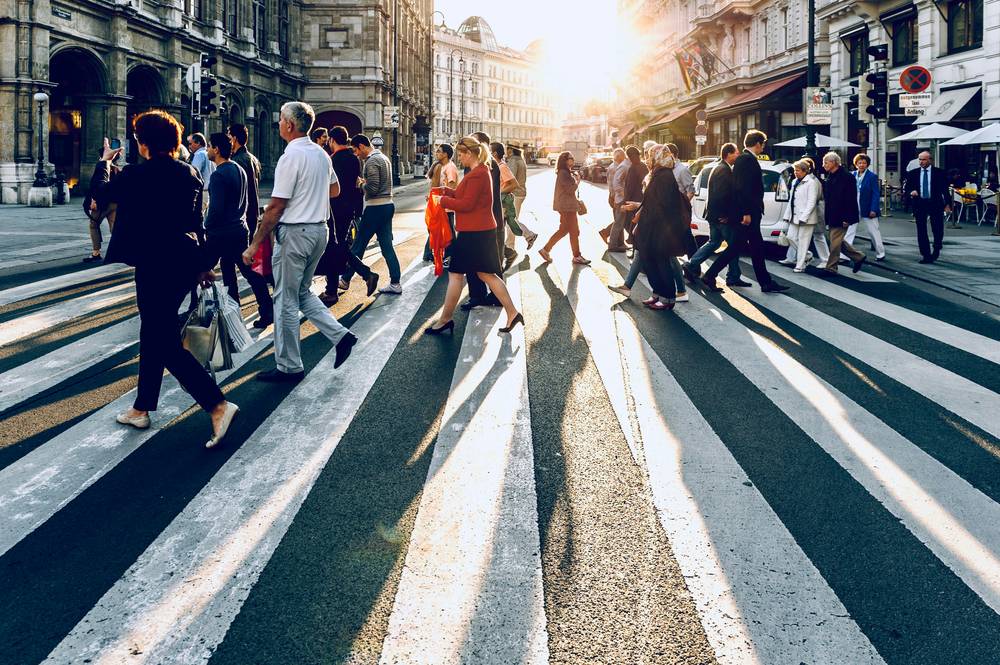Multidão andando apressada na cidade, simbolizando o custo da alta performance na saúde mental